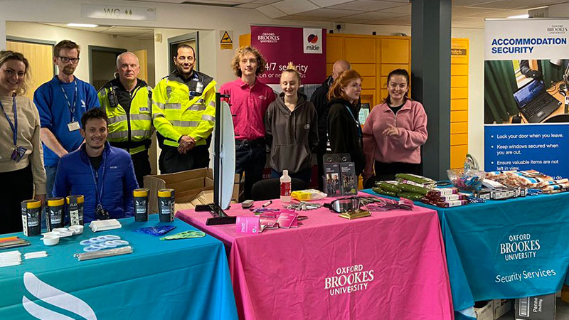Oxford Brookes staff standing behind stalls at the halls to home event